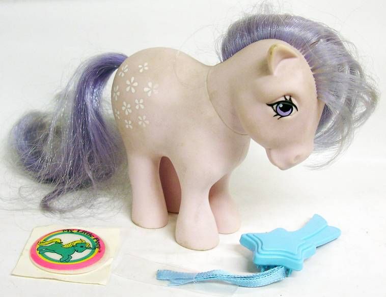 White Earth Pony in lavender-colored hair, tail, and eyes looking in a blue star toy on the floor